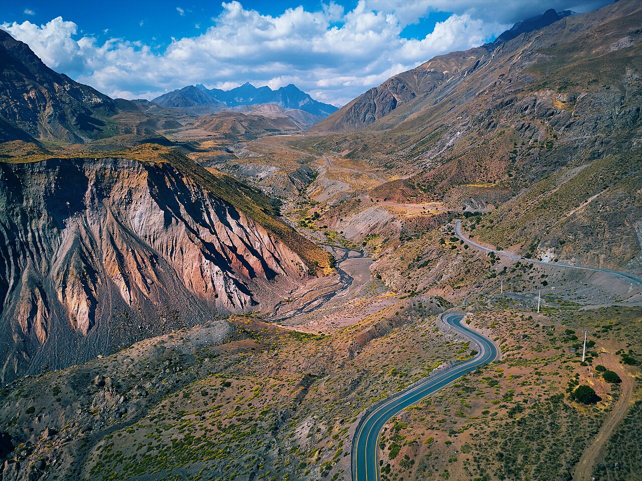 Camino sinuoso entre montañas y el cauce de un río en el Cajón del Maipo.